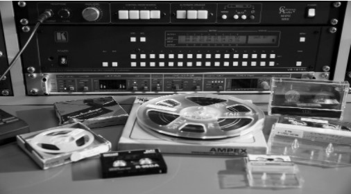 Audio equipment with tapes and reel to reel recordings in foreground