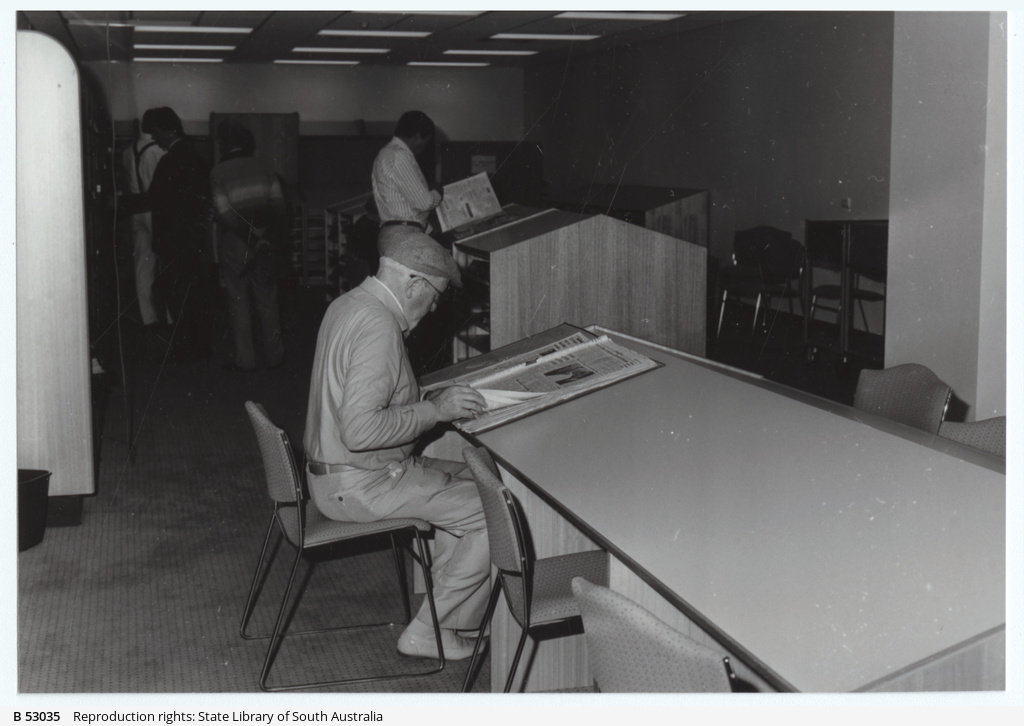 State Library of South Australia Newspaper Reading Area in 1990, a man is reading a newspaper at a sloped table