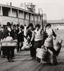 Black and white photo of people alighting at a dock